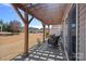 Shaded patio with seating area overlooking expansive backyard, with mature trees and sunny sky at 3100 Azalea Dr, Fort Mill, SC 29707
