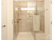 Bathroom shower with glass door, bench, neutral colored tiles, and a window at 3102 Arches Bluff Cir, Lancaster, SC 29720