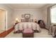 Bedroom with neutral tones, patterned comforter, end tables and sitting area at 3102 Arches Bluff Cir, Lancaster, SC 29720