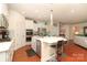 Bright kitchen featuring white cabinetry, stainless steel appliances, island with bar seating, and hardwood floors at 3102 Arches Bluff Cir, Lancaster, SC 29720