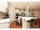 Bright kitchen featuring white cabinetry, stainless steel appliances, island with bar seating, and hardwood floors at 3102 Arches Bluff Cir, Lancaster, SC 29720