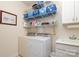 Laundry room featuring a washer, dryer, sink, and storage shelves at 3102 Arches Bluff Cir, Lancaster, SC 29720