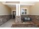 Cozy front porch area with stone accents, a comfortable bench, and a decorative front door at 3102 Arches Bluff Cir, Lancaster, SC 29720