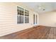 Covered back porch with wooden floors and a large window offering natural light and outdoor views at 3104 Streamhaven Dr, Indian Land, SC 29707