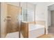 Nicely tiled shower stall and bath tub in this luxurious ensuite bathroom at 3104 Streamhaven Dr, Indian Land, SC 29707