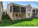 Back exterior of house with screened in porch and grassy yard at 3104 Streamhaven Dr, Indian Land, SC 29707