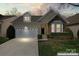 Charming home with a two-car garage, stone accents, and well-maintained landscaping at 3104 Streamhaven Dr, Indian Land, SC 29707
