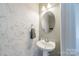 Stylish half bath featuring an oval mirror and pedestal sink at 3104 Timber Mill Dr, Matthews, NC 28104