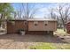 View of the back of the house with brick and siding and yard with trees in the background at 326 Whispering Pines Dr, Charlotte, NC 28217
