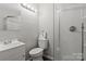 Bathroom featuring a glass door shower, toilet, and vanity with updated lighting and hardware at 326 Whispering Pines Dr, Charlotte, NC 28217