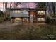 Charming split-level home featuring a brick facade, gray siding, and a well-manicured lawn at 326 Whispering Pines Dr, Charlotte, NC 28217
