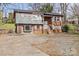 Charming split-level home featuring a brick facade, gray siding, and a spacious driveway at 326 Whispering Pines Dr, Charlotte, NC 28217