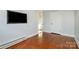 Bedroom with hardwood flooring, features a closet and wall-mounted television at 36 Yorktown Nw St, Concord, NC 28025