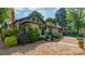 Charming green craftsman-style home with a welcoming front porch and beautifully landscaped front yard and a brick chimney at 36 Yorktown Nw St, Concord, NC 28025