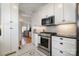 Well-lit kitchen featuring stainless steel appliances, white cabinetry, and charming backsplash design at 36 Yorktown Nw St, Concord, NC 28025