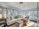 Light-filled sunroom with neutral paint, large windows, comfortable seating, and a plush ottoman at 36 Yorktown Nw St, Concord, NC 28025