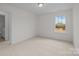 Bright bedroom with neutral carpet, a single window and a door, offers a blank canvas for design at 4127 Walking Ridge Rd # 53, Charlotte, NC 28208