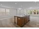 Open-concept kitchen with an island featuring a sink, wood cabinets, and hardwood floors at 4127 Walking Ridge Rd # 53, Charlotte, NC 28208