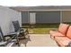 Backyard featuring a small patio with an orange sofa, grey rocking chairs, and privacy fence at 426 Kenwood Vw, Indian Trail, NC 28079