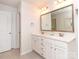 Bright bathroom featuring double vanity and framed mirror with an adjacent doorway at 426 Kenwood Vw, Indian Trail, NC 28079