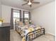 Bedroom with natural light featuring a ceiling fan, dark metal bed frame, and carpeted floors at 426 Kenwood Vw, Indian Trail, NC 28079