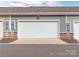 Attached one car garage with a white door and stone veneer on the bottom at 426 Kenwood Vw, Indian Trail, NC 28079