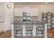 Kitchen island with seating, white cabinetry, stainless steel appliances, and modern lighting at 426 Kenwood Vw, Indian Trail, NC 28079