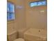 Bright bathroom features a white tiled shower-tub combination and a window for natural light at 4612 Waterbell Ln, Waxhaw, NC 28173