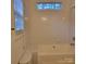 Bright bathroom features a white tiled shower-tub combination and a window for natural light at 4612 Waterbell Ln, Waxhaw, NC 28173