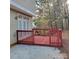 Back porch with a view of a wooded yard with a red-stained deck and railings at 4612 Waterbell Ln, Waxhaw, NC 28173