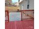 Back porch with a view of the backyard with a red-stained deck and railings at 4612 Waterbell Ln, Waxhaw, NC 28173