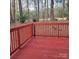 Inviting red-stained wood deck surrounded by a wooded landscape, perfect for outdoor relaxation at 4612 Waterbell Ln, Waxhaw, NC 28173