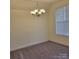 Bright room with plush carpet and a modern chandelier, illuminated by natural light from the window at 4612 Waterbell Ln, Waxhaw, NC 28173