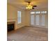 Living room with carpet, ceiling fan, fireplace with tile surround and double french doors for a view to the backyard at 4612 Waterbell Ln, Waxhaw, NC 28173