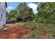 Unfinished backyard showing weeds and construction refuse beyond a covered new home at 5005 County Home Rd, Conover, NC 28613
