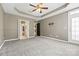 Neutral bedroom features carpet, trey ceiling, and fan, with a door to the bathroom at 5959 Pale Moss Ln, Charlotte, NC 28269