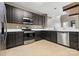 Functional kitchen with dark cabinetry, stainless steel appliances, and tile flooring at 5959 Pale Moss Ln, Charlotte, NC 28269
