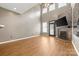 Spacious living room with high ceilings, wood floors, a fireplace, and stone wall at 5959 Pale Moss Ln, Charlotte, NC 28269