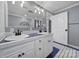 Bathroom with double sinks, white cabinets and blue tile accents at 6823 City View Dr, Charlotte, NC 28212