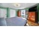 Bright bedroom featuring hardwood floors, a TV, and plenty of closet space at 6823 City View Dr, Charlotte, NC 28212
