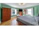 Bright bedroom featuring hardwood floors, a TV, and plenty of natural light from two windows at 6823 City View Dr, Charlotte, NC 28212
