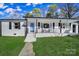 Stylish house front featuring a light blue door, covered porch and landscaped lawn at 6823 City View Dr, Charlotte, NC 28212
