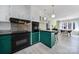 Unique kitchen with green cabinets, modern lighting, and a connected dining space at 6823 City View Dr, Charlotte, NC 28212
