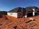 View of a new construction home with black roof and siding barrier ready for exterior finishing at 713 Inwood Hill Dr # 96, Gastonia, NC 28056