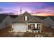 Charming single-story home featuring a covered porch with rocking chairs and a well-manicured front yard at 7172 Indigo Way, Denver, NC 28037