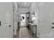 Inviting hallway with decor featuring a mirror, console table, and wood flooring leads to the open front door at 7172 Indigo Way, Denver, NC 28037