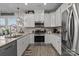 Modern kitchen with white cabinets, stainless steel appliances, and plenty of counter space for food preparation at 7172 Indigo Way, Denver, NC 28037