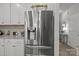 Modern kitchen boasts stainless steel refrigerator, white cabinets and gray backsplash at 7172 Indigo Way, Denver, NC 28037