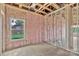 Bedroom under construction with wooden framing, pink insulation, and window offering an outside view at 8455 W Nc 152 Hwy, Mooresville, NC 28115