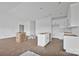 Open-concept kitchen featuring white cabinets and a central island, awaiting finishing touches at 8455 W Nc 152 Hwy, Mooresville, NC 28115